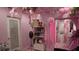 Salon interior with pink walls, black chairs and styling equipment, floral ceiling decor and marble like floors at 12425 Ridge Rd, Largo, FL 33778