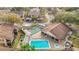 Aerial view of a community pool and shuffleboard court with lounge chairs and building at 12804 Wedgewood Way # C, Hudson, FL 34667