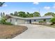 Well-maintained single-story home features a spacious driveway leading to an attached two-car garage at 13211 111Th Ln, Largo, FL 33778