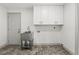 Laundry room with stainless steel sink, storage cabinets, and tile flooring at 13211 111Th Ln, Largo, FL 33778