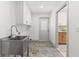 Laundry room with stainless steel utility sink, tile flooring, and white cabinets at 13211 111Th Ln, Largo, FL 33778