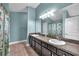 En-suite bathroom with dual sinks, vanity, and large mirror at 14233 Edinburgh Moor Dr, Wimauma, FL 33598