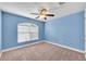 Carpeted secondary bedroom featuring a ceiling fan and a light blue painted wall at 14233 Edinburgh Moor Dr, Wimauma, FL 33598