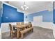 Dining room boasting a wooden table with bench seating, bright walls, and modern lighting at 14233 Edinburgh Moor Dr, Wimauma, FL 33598