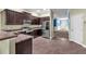 Contemporary kitchen with stainless steel appliances, dark wood cabinetry, and tile flooring at 14233 Edinburgh Moor Dr, Wimauma, FL 33598
