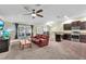 Spacious living room with adjoining kitchen, carpeted floors, and plenty of natural light at 14233 Edinburgh Moor Dr, Wimauma, FL 33598