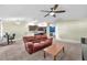 Open-concept living room with a ceiling fan and view of the kitchen's breakfast bar at 14233 Edinburgh Moor Dr, Wimauma, FL 33598