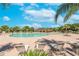 Community pool with lounge chairs, landscaping, and a covered area for residents to relax and enjoy at 14233 Edinburgh Moor Dr, Wimauma, FL 33598