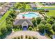 Aerial view of community pool and clubhouse surrounded by lush landscaping and well-maintained grounds at 14233 Edinburgh Moor Dr, Wimauma, FL 33598