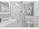 Modern bathroom featuring a white tiled shower with glass door, white sink, and toilet at 157 9Th N Ave, St Petersburg, FL 33701