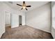 This carpeted bedroom features a ceiling fan, window, and access to a walk-in closet at 15810 Starling Water Dr, Lithia, FL 33547