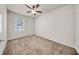 Carpeted bedroom with a ceiling fan and bright window for natural light and ventilation at 15810 Starling Water Dr, Lithia, FL 33547