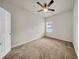 This carpeted bedroom includes a ceiling fan, window, and doorway access at 15810 Starling Water Dr, Lithia, FL 33547