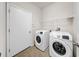 Functional laundry room with modern washer, dryer, and storage shelf at 15810 Starling Water Dr, Lithia, FL 33547