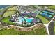 Aerial view of a community pool and clubhouse, showcasing amenities, green spaces, and meticulous landscaping at 1738 Longliner Loop, Wesley Chapel, FL 33543