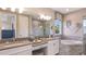 Bright bathroom boasts double sinks, marble floors and shower, tub, and stylish lighting at 1738 Longliner Loop, Wesley Chapel, FL 33543