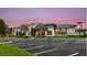Modern clubhouse showcasing sleek architecture, ample parking, and vibrant landscaping under a twilight sky at 1738 Longliner Loop, Wesley Chapel, FL 33543