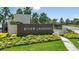 Community entrance featuring a modern sign with lush landscaping and palm trees, creating a welcoming atmosphere at 1738 Longliner Loop, Wesley Chapel, FL 33543