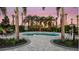 Relaxing hot tub area surrounded by lush landscaping, palm trees, and comfortable seating under a twilight sky at 1738 Longliner Loop, Wesley Chapel, FL 33543