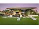Inviting outdoor lounge area with comfortable seating, a large TV, and a well-manicured lawn for games at 1738 Longliner Loop, Wesley Chapel, FL 33543