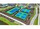 Aerial view of well-maintained tennis and pickleball courts, surrounded by lush landscaping and walking paths at 1738 Longliner Loop, Wesley Chapel, FL 33543