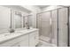 Bathroom featuring a double sink vanity with quartz countertop and glass-enclosed shower at 20417 Symphony Pl, Venice, FL 34293