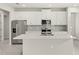 Modern kitchen features stainless steel appliances, a large island, and sleek white cabinetry at 20417 Symphony Pl, Venice, FL 34293