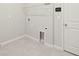 A well-lit laundry room with gray tile flooring, hookups, and a storage shelf at 20417 Symphony Pl, Venice, FL 34293