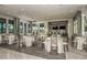 A spacious meeting room featuring tables with white linens and a wet bar for hosting events at 20417 Symphony Pl, Venice, FL 34293