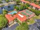 Aerial view features pool, tennis court, and clubhouse of a community with a lake and fountain nearby at 2400 Feather Sound Dr # 1136, Clearwater, FL 33762