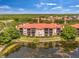 Aerial view of the community buildings with screened patios, green lawn and nearby pond at 2400 Feather Sound Dr # 1136, Clearwater, FL 33762