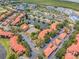 Community aerial showcasing pool, tennis courts, lake, and convenient parking between residential buildings at 2400 Feather Sound Dr # 1136, Clearwater, FL 33762