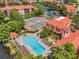 Aerial view showcases pool, tennis courts and lush landscaping in a vibrant community with nearby condo buildings at 2400 Feather Sound Dr # 1136, Clearwater, FL 33762