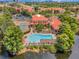 Stunning aerial view of a resort style community with a pool, tennis courts, and lush landscaping near a lake at 2400 Feather Sound Dr # 1136, Clearwater, FL 33762