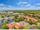 Community aerial view of pool, tennis court, and clubhouse by a lake near condos and natural preserve at 2400 Feather Sound Dr # 1136, Clearwater, FL 33762