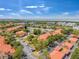 Aerial view showing a complex with tennis courts and pool amid lush landscaping and convenient parking at 2400 Feather Sound Dr # 1136, Clearwater, FL 33762