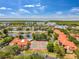 Aerial community view featuring pool, tennis courts, lake, and surrounding residences near a preserve at 2400 Feather Sound Dr # 1136, Clearwater, FL 33762