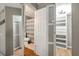 This shows a bathroom and closet with shelving in them, with doors open at 2400 Feather Sound Dr # 1136, Clearwater, FL 33762