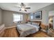 Relaxing bedroom with wood flooring, a ceiling fan, large window and a comfortable bed at 2400 Feather Sound Dr # 1136, Clearwater, FL 33762