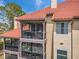 Exterior view showing several levels of screened patios with a red tile roof at 2400 Feather Sound Dr # 1136, Clearwater, FL 33762