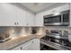 This kitchen has stainless steel appliances and granite countertops with a decorative backsplash at 2400 Feather Sound Dr # 1136, Clearwater, FL 33762