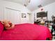 Bright bedroom featuring a red comforter, closet, and a ceiling fan at 24305 Denali Ct, Lutz, FL 33559