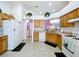 Open kitchen with wood cabinets, white appliances, view to a breakfast nook and purple dining room at 24305 Denali Ct, Lutz, FL 33559
