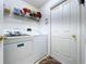 Cozy laundry room with front load washer and dryer, plus wire shelving for storage at 24305 Denali Ct, Lutz, FL 33559