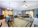 Open-concept living and dining area featuring a chandelier, blue paint, and a comfortable sectional sofa at 24305 Denali Ct, Lutz, FL 33559