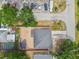Overhead view of a well-maintained property featuring a gray roof, brick patio, and lush greenery surrounding the home at 2701 W Osborne Ave, Tampa, FL 33614