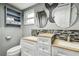 Bathroom featuring double sink vanity with granite countertop and decorative mosaic backsplash at 2701 W Osborne Ave, Tampa, FL 33614