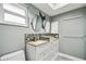 Modern bathroom featuring double sink vanity with granite countertop and decorative mosaic backsplash at 2701 W Osborne Ave, Tampa, FL 33614