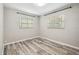 Neutral bedroom features gray wood-look floors and two windows at 2701 W Osborne Ave, Tampa, FL 33614