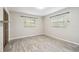 An empty bedroom with neutral walls, wood-look floors, and two windows at 2701 W Osborne Ave, Tampa, FL 33614